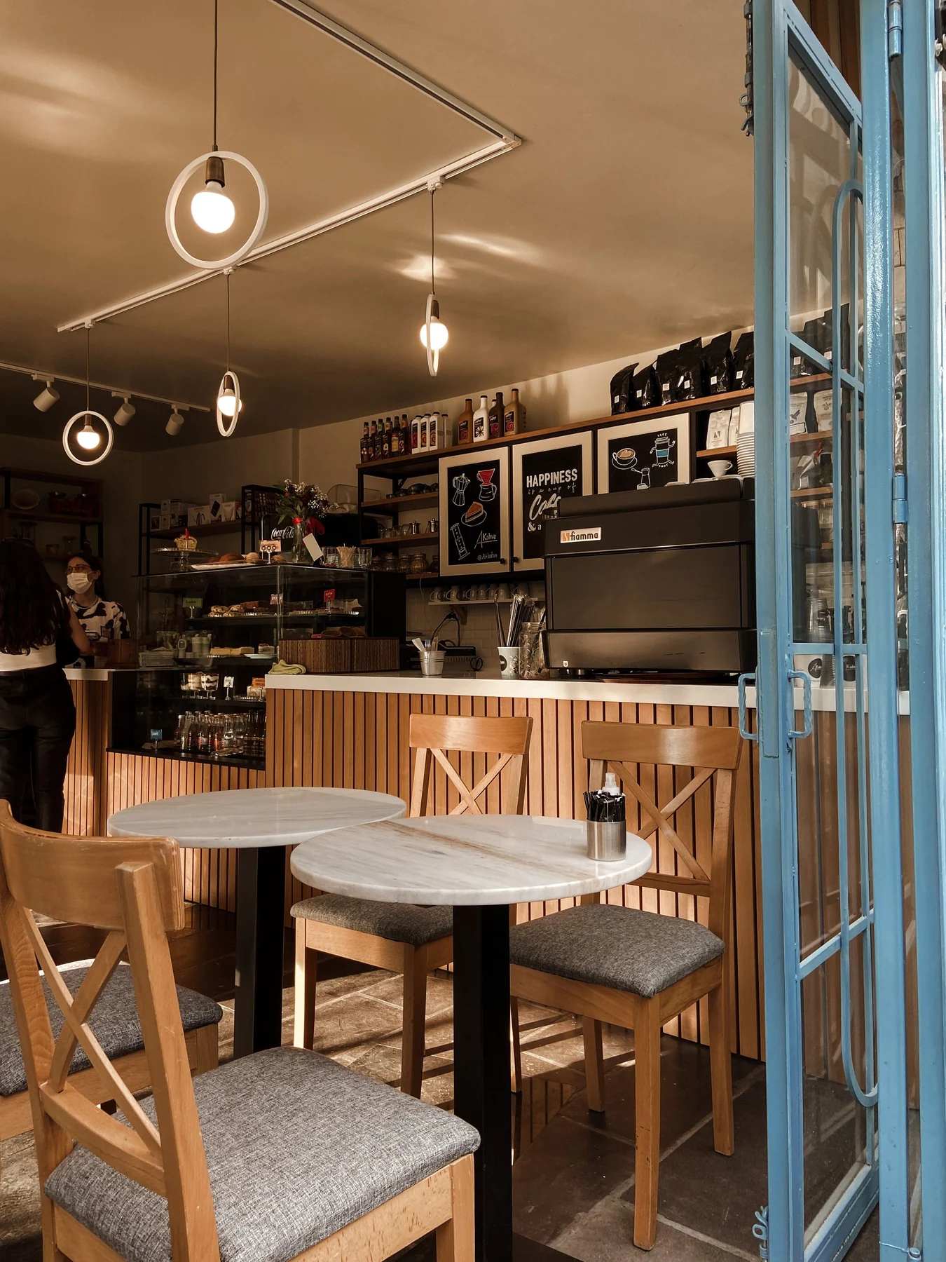 Café mit Holztischen, Stühlen und warmem Licht