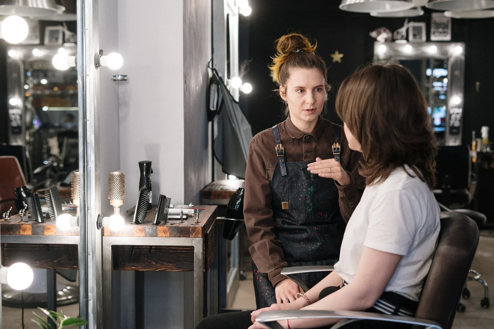 Friseurin im Beratungsgespräch mit einer Kundin im Salon