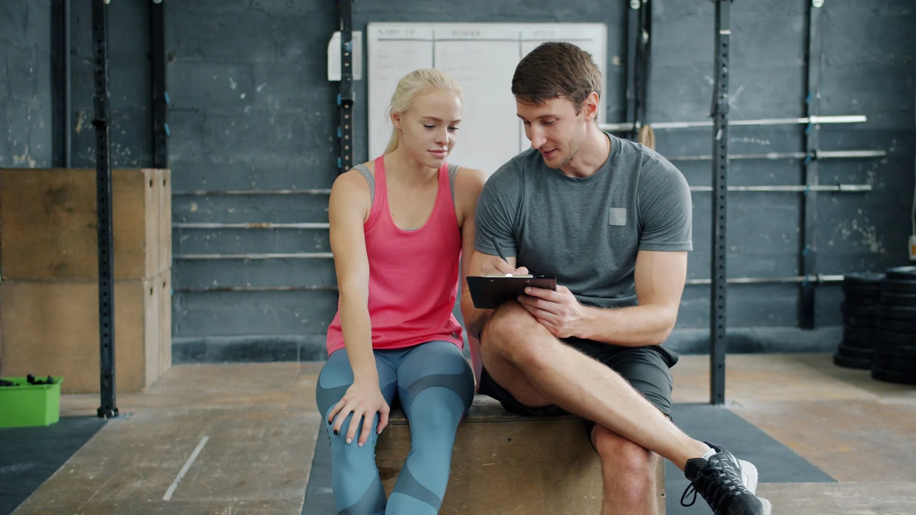 Trainer und Kunde besprechen einen Trainingsplan im Studio