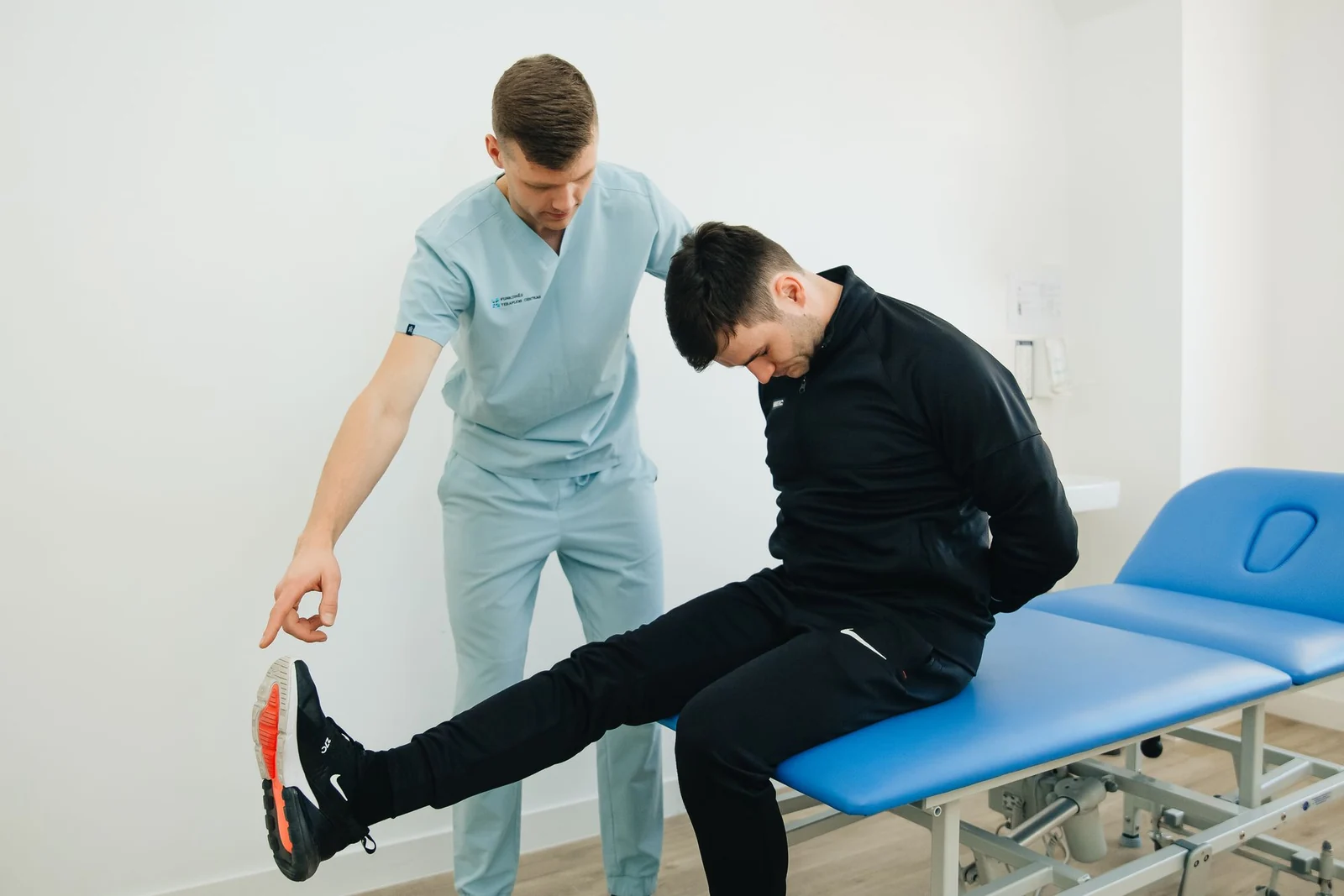 Physiotherapeut erläutert einem Patienten eine Übung in einer Praxis